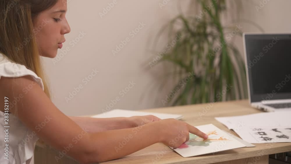 A side view of a teenage girl describing Rorschach inkblot image during psychoanalytical session. Therapist examining patients personality characteristics A side view of a teenage girl describing Rorschach inkblot image during psychoanalytical session. Therapist examining patients personality characteristics