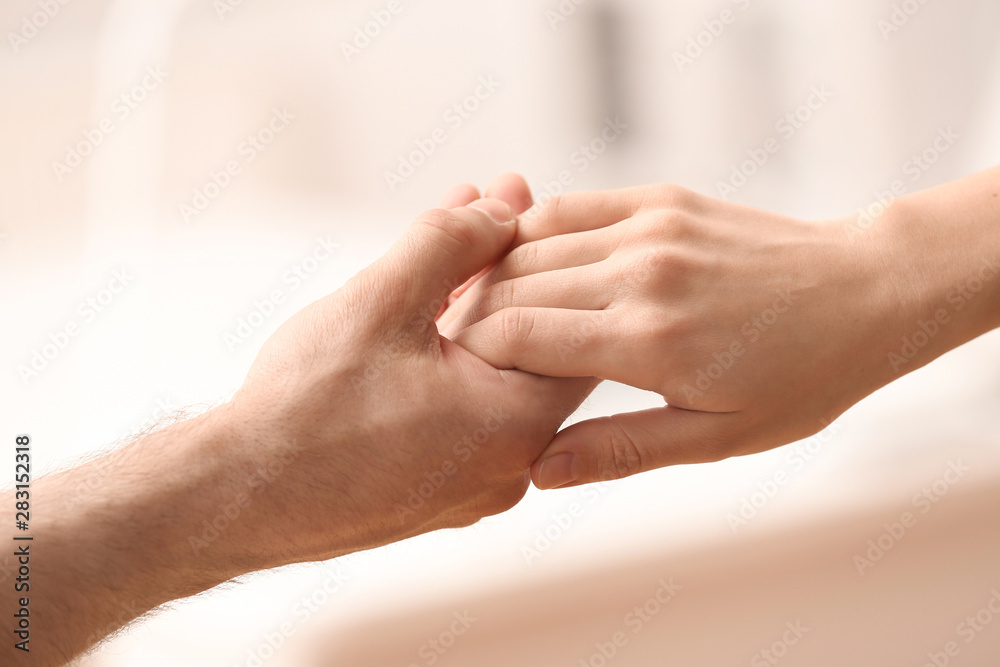 People holding hands against blurred background, closeup People holding hands against blurred background, closeup