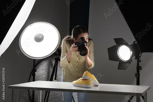 Professional photographer shooting stylish shoes in studio photo