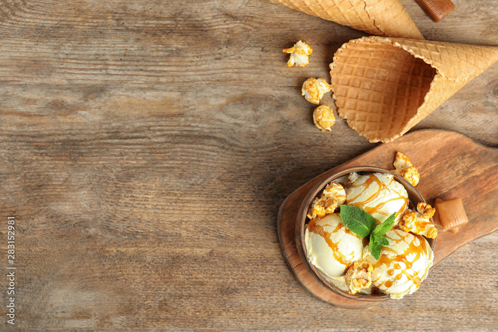 Fototapeta premium Flat lay composition with delicious ice cream on wooden table. Space for text