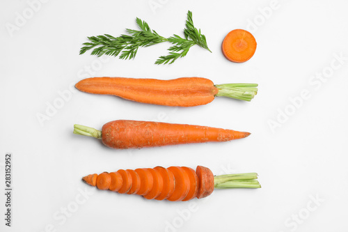 Tasty ripe carrots and leaves isolated on white, top view