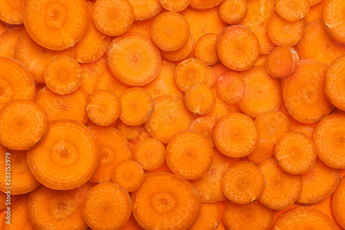 Slices of fresh raw carrots as background, top view