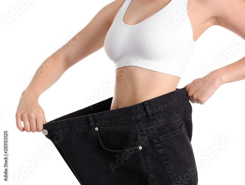 Young slim woman wearing oversized jeans on white background, closeup © New Africa