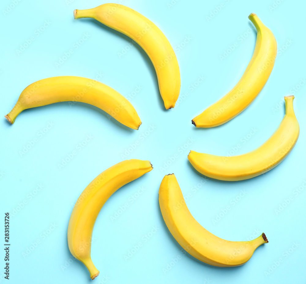 Ripe tasty bananas on blue background, flat lay