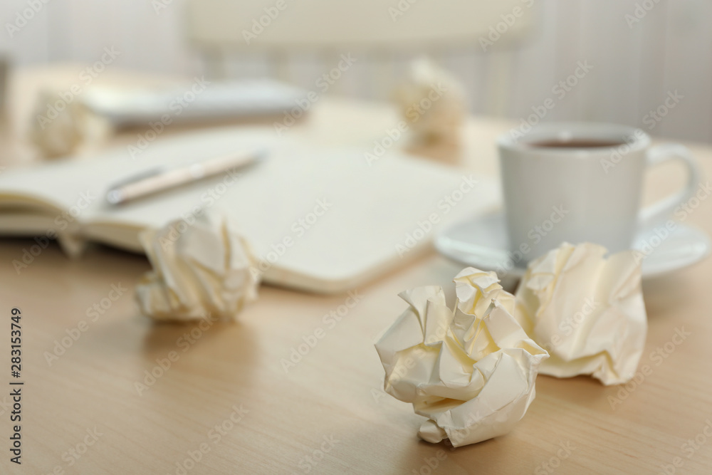 Sheets of crumpled paper and cup on wooden table, space for text Sheets of crumpled paper and cup on wooden table, space for text