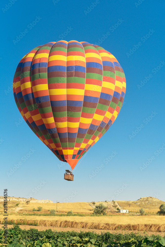 Multi-colored balloon flying in the sky in Cappadocia Turkey