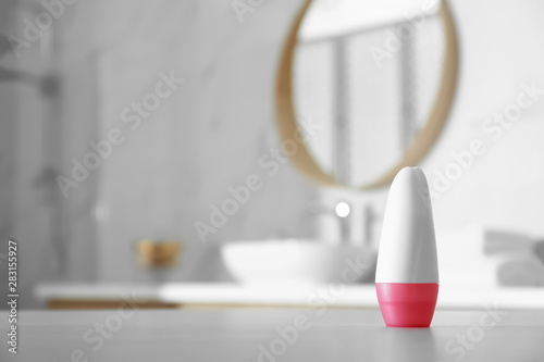 Deodorant container on table in bathroom. Space for text