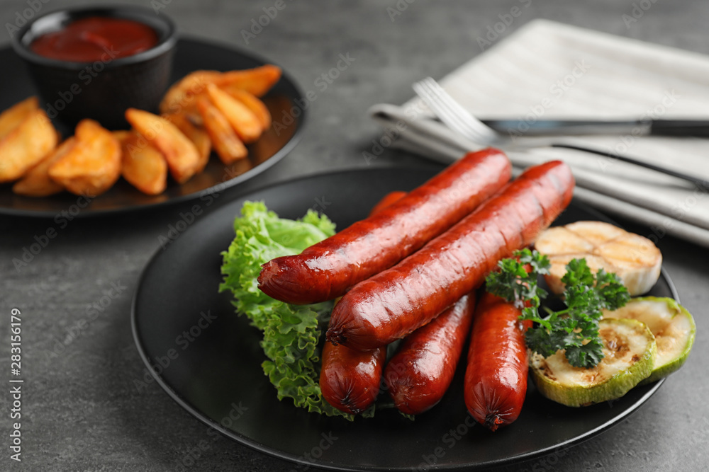 Delicious grilled sausages and vegetables on grey table Delicious grilled sausages and vegetables on grey table