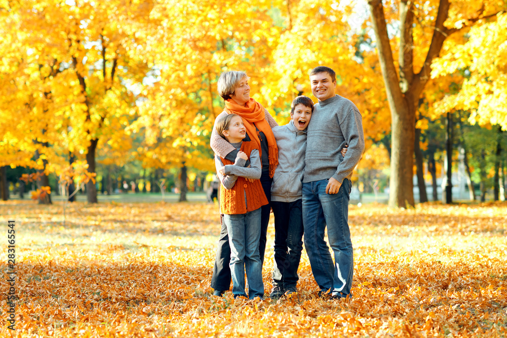 Happy family posing, playing and having fun in autumn city park. Children and parents together having a nice day. Bright sunlight and yellow leaves on trees, fall season. Happy family posing, playing and having fun in autumn city park. Children and parents together having a nice day. Bright sunlight and yellow leaves on trees, fall season.