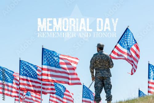 Fotografie man in military uniform and cap standing and holding american flag with memorial