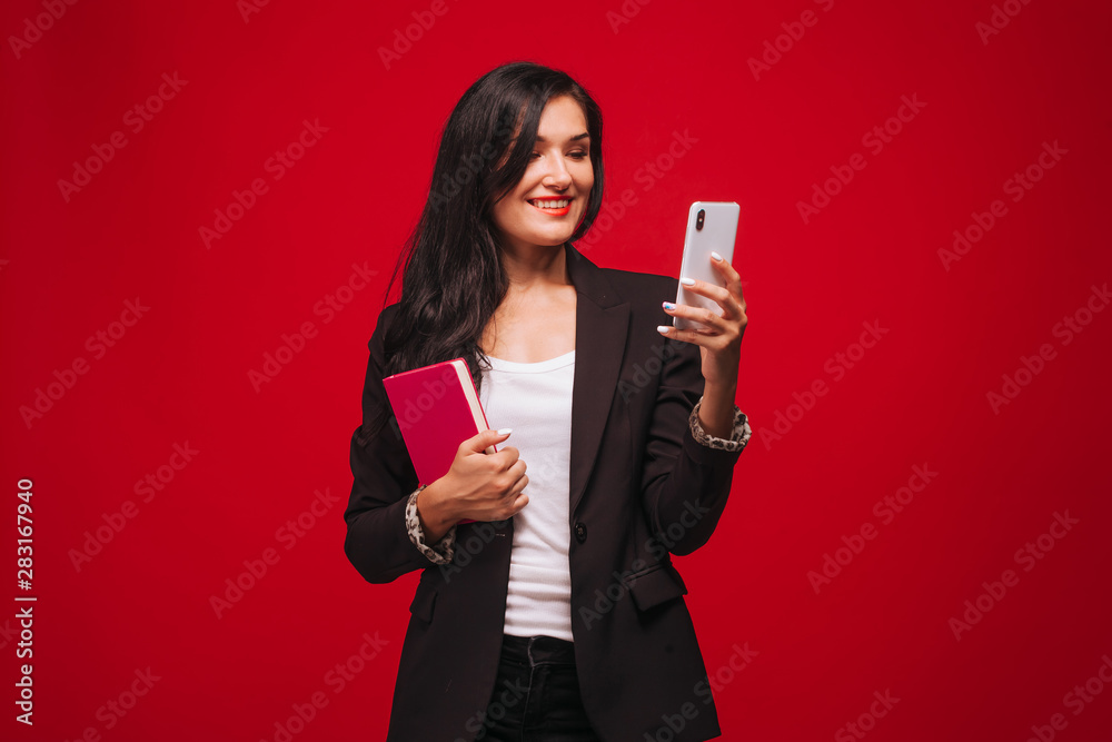 A girl talking on the phone and holding a diary A girl talking on the phone and holding a diary