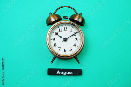 Alarm clock and September calendar with space copy on green mint background