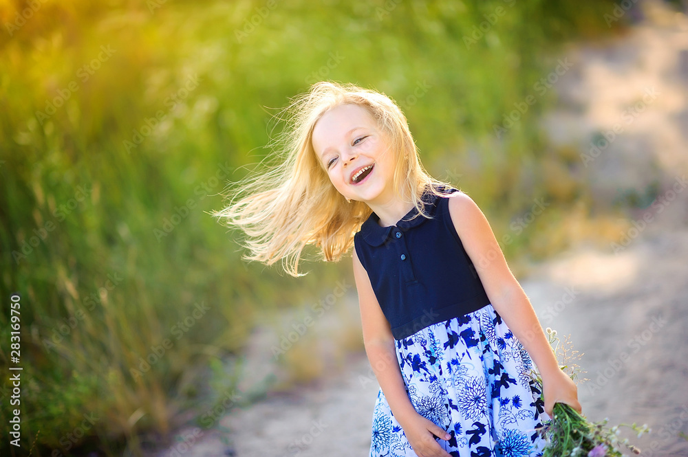 cute little girl plays outdoors at sunset, holds a bouquet of wildflowers and walks around the field, happy childhood cute little girl plays outdoors at sunset, holds a bouquet of wildflowers and walks around the field, happy childhood