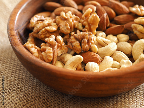 walnuts, cashews and almonds in a wooden plate. healthy foods