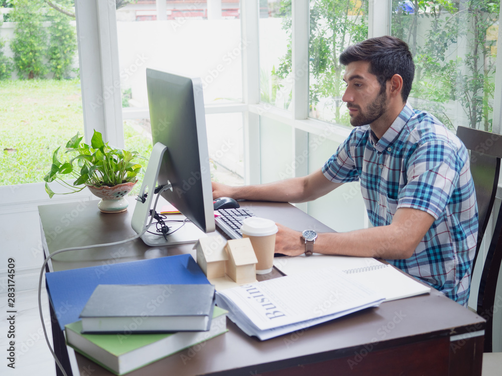 young man working at home ,businessman works on his computer to get all his business young man working at home ,businessman works on his computer to get all his business