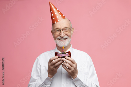 Photography Attractive happy retired Caucasian male wearing bow tie, glasses and cone hat ce