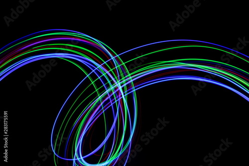 Long exposure, light painting photography. Vibrant streaks of neon multi color against a black background. © LizFoster