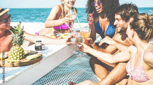 Canvas Print Group of happy friends cheering with tropical cocktails at boat party - Young pe