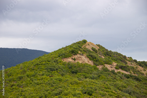 Southern highlands. Field with low mountains. Low mountains with trees. Anapsky district, Russia. Summer mountain landscape