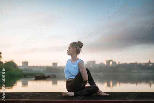 Girl practice yoga early morning on pier
