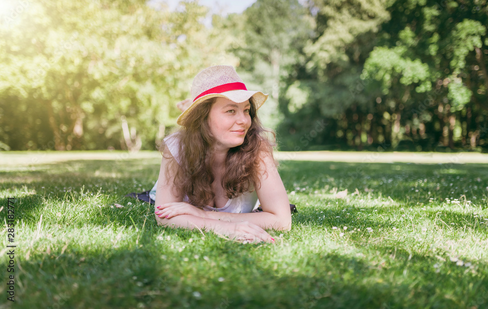 Woman outdoor portrait. Happy, young woman laying on green grass, in summer park. Woman outdoor portrait. Happy, young woman laying on green grass, in summer park.