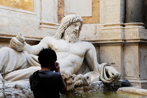 Photography Marphurius or Marforio talking statues of Rome with an asian visitor taking a photo