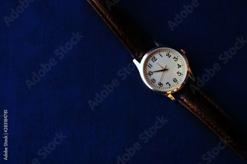 Gold and quartz watch on a black background.