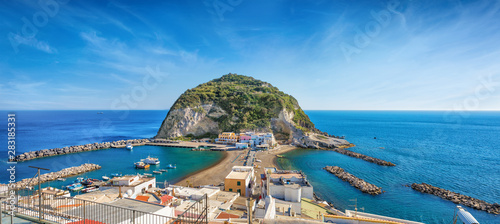 Panoramic view of beautiful coast of village Sant'Angelo, giant green rock in blue sea near Ischia Island, Italy.