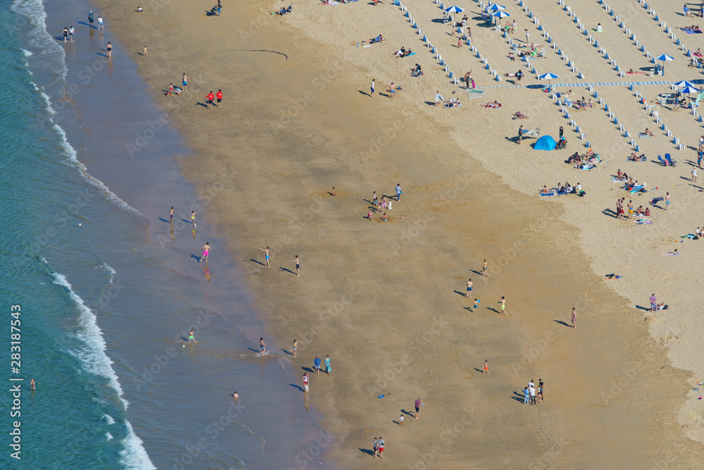 Aerial View From The Mountain Of People Relaxing On Beach In Spain. Aerial View From The Mountain Of People Relaxing On Beach In Spain.