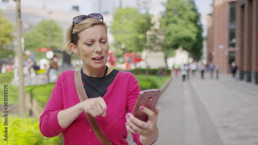 Young female using sign language on a video call as she walks in the city