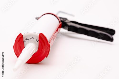 Caulking gun and white silicone sealant