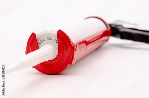 Caulking gun and white silicone sealant