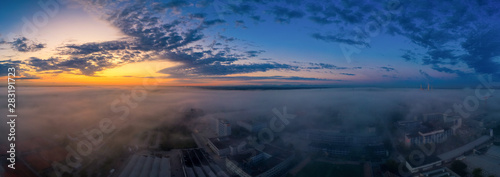 A very foggy sunrise over an industrial aera