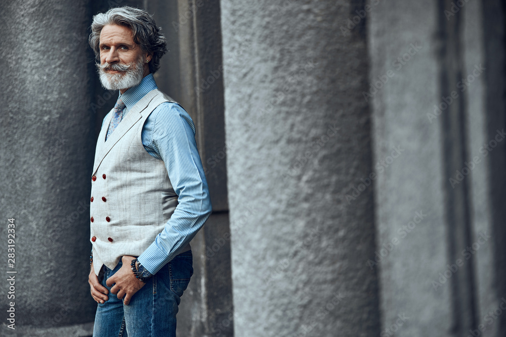 Calm smiling bearded man near the building stock photo Calm smiling bearded man near the building stock photo
