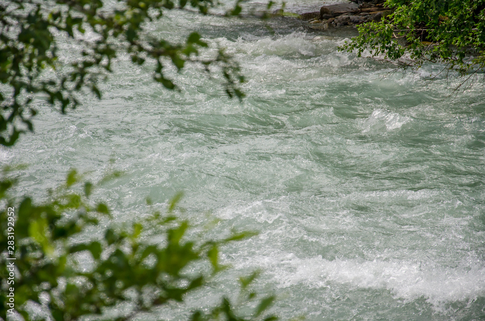 Wild river of Rhone (Rotten) in alpine valley of Goms (Wallis) in Switzerland. A lot of water streaming in rapids. Wild river of Rhone (Rotten) in alpine valley of Goms (Wallis) in Switzerland. A lot of water streaming in rapids.