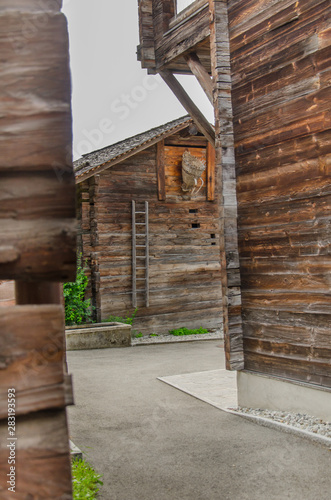 Wooden houses and sheds in rural village in Swiss alps in Valais valley on a summer day