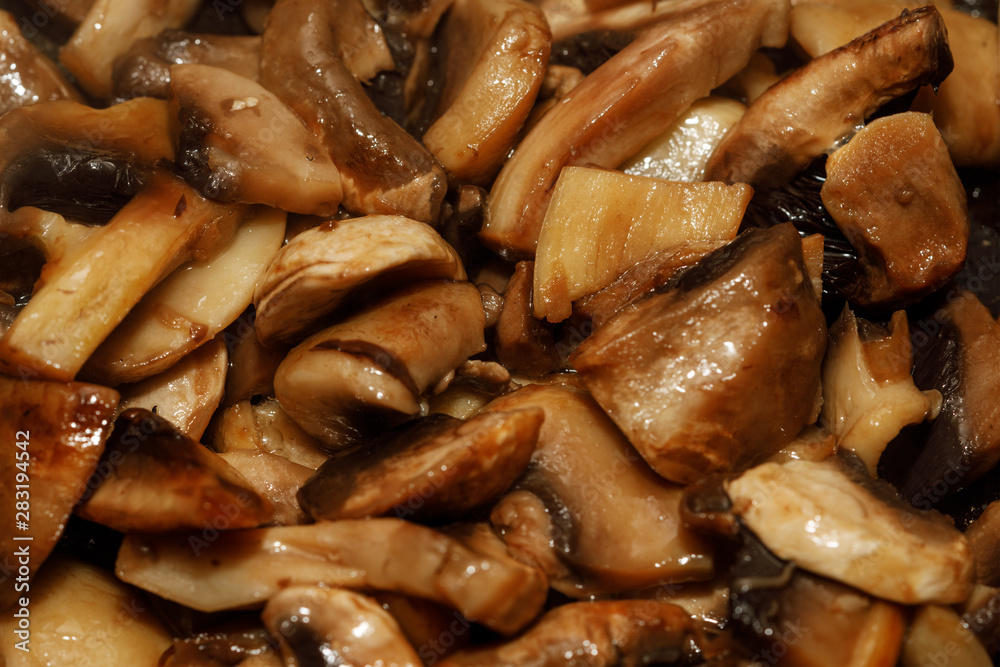 Fried champignon mushrooms in a pan closeup background texture Fried champignon mushrooms in a pan closeup background texture