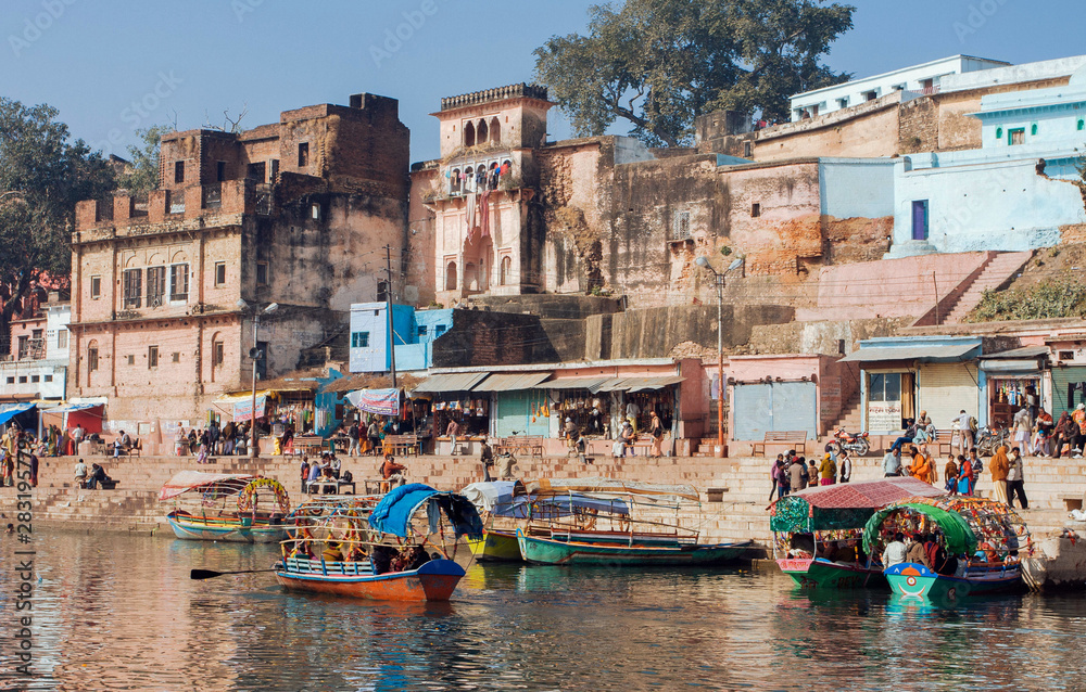 Crowd of people in ancient city and riverside with riverboats along market streets