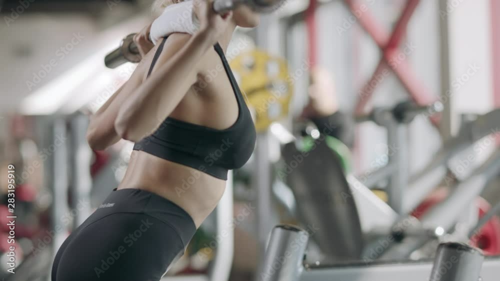 Strong woman doing squat exercise with barbell in fitness center. Strong woman doing squat exercise with barbell in fitness center.