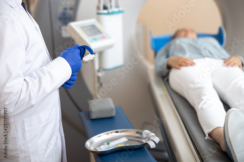 Doctor in sterile gloves holding venous tourniquet photo