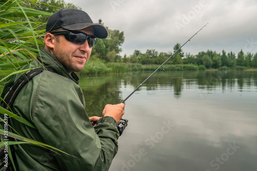 Fishing. Fisherman in action, man catch fish by spinning rod