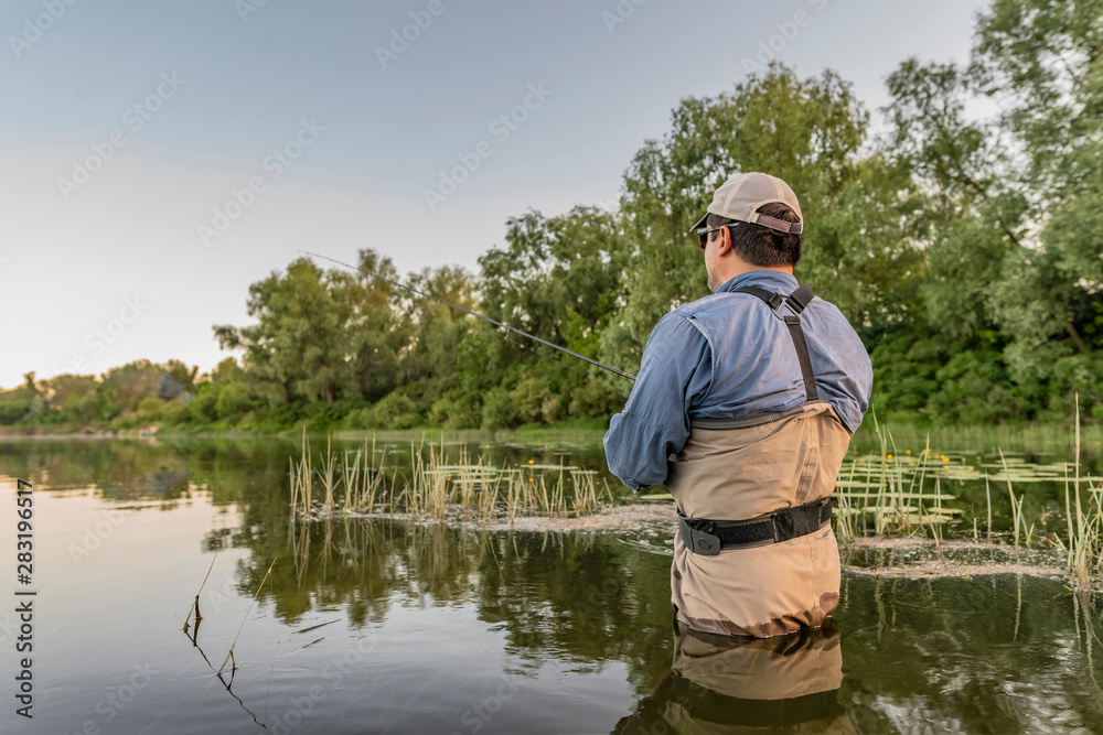 Fishing. Fisherman in action, lonely man catch fish by spinning rod