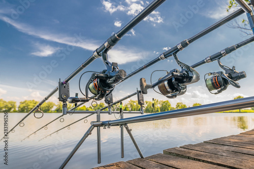 Carp fishing. Rods on rod pod on wood platform at lake