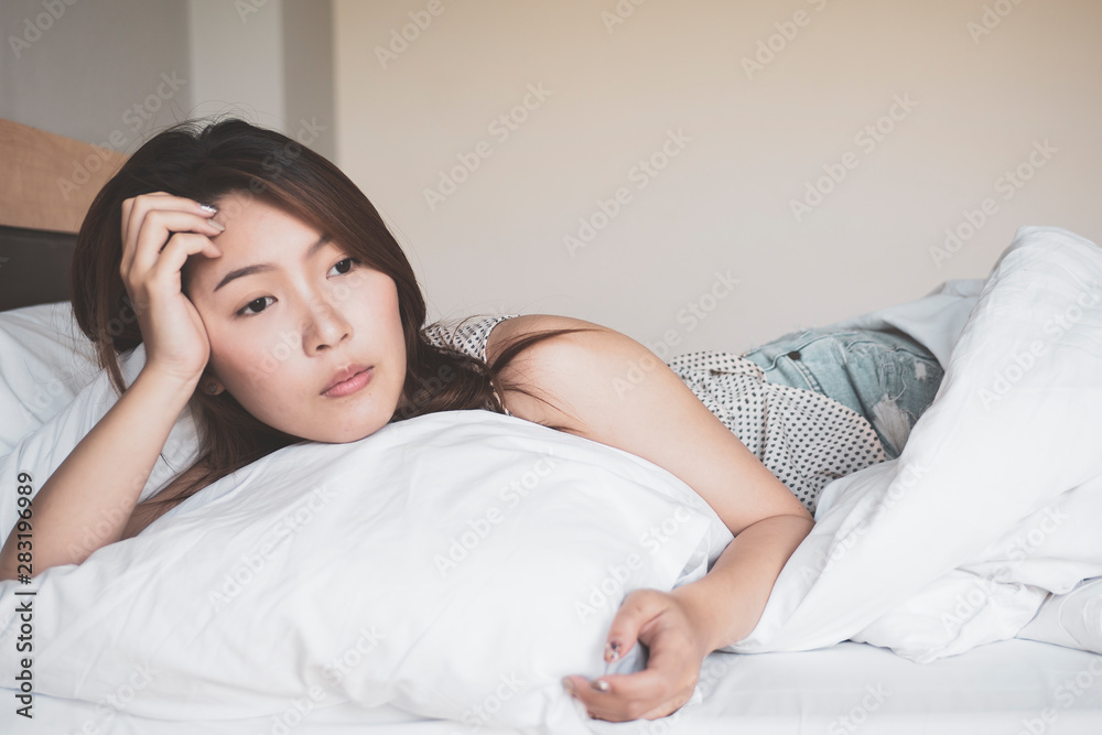 Young asian woman in sad laying on a bed Young asian woman in sad laying on a bed