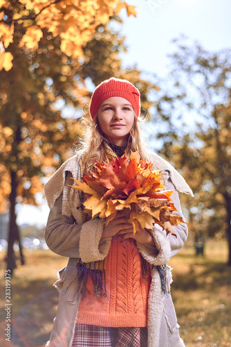 autumn portrait of cute girl in  red hat and coat