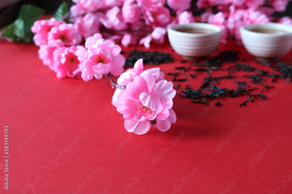 Chinese tea ceremony with the use of utensils of clay on the background of the cherry blossom.