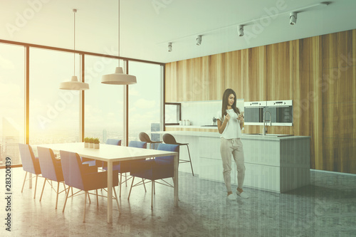 Woman in wooden kitchen corner with table