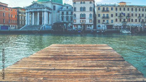 Old wooden pier and beautiful view on venetian chanal with Gondola parking. Picturesque landscape. Venice is a popular tourist destination of Europe. photo