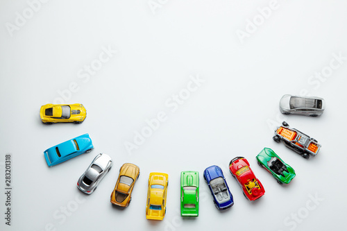Photography Many colored little toy cars on a gray background.
