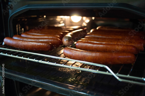 Cooking sausages in the oven. Fast food street. Fried sausages
